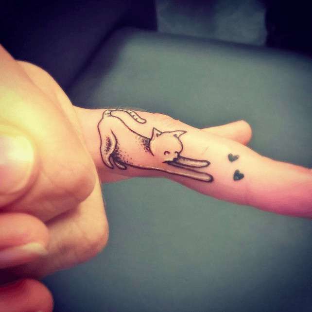 Tatuaje pequeño de gatito en el dedo