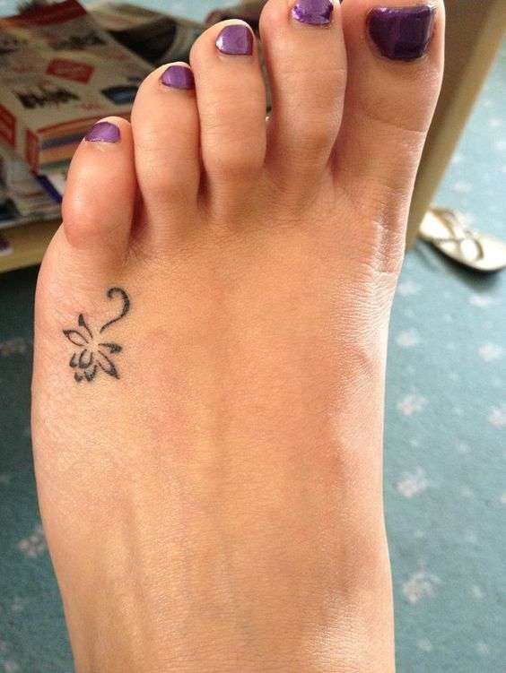 Tatuaje pequeño de flor en el pie