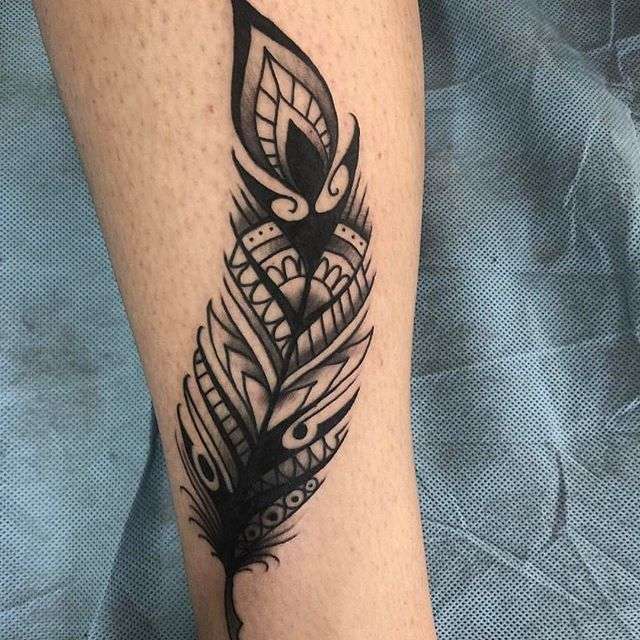 Tatuaje de pluma en la pierna