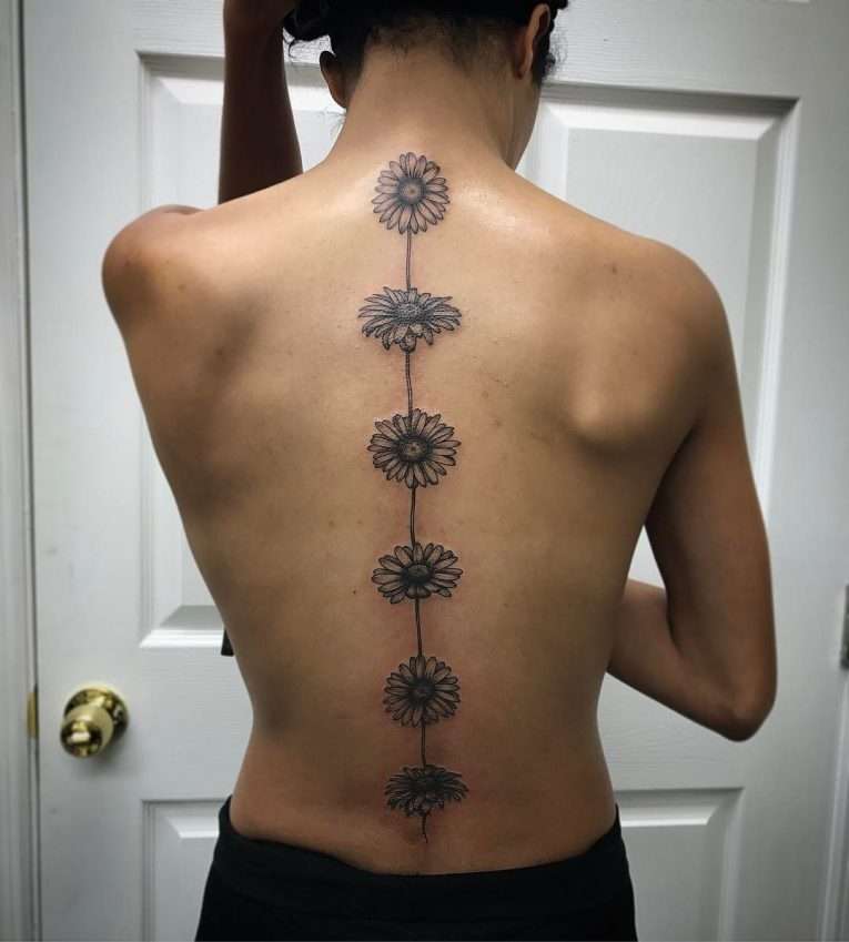 Tatuaje de margaritas en la columna vertebral