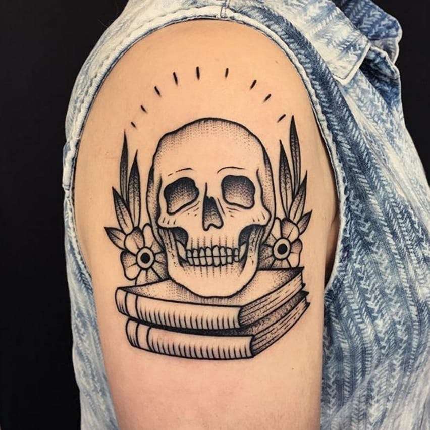 Tatuaje de calavera sobre dos libros